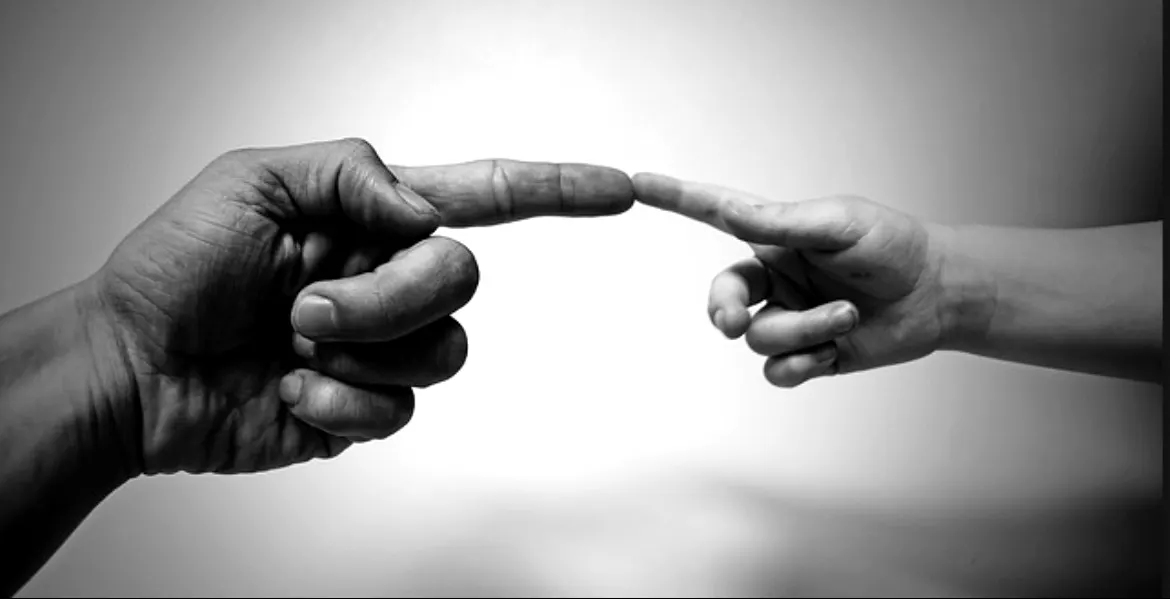 Two hands reaching toward each other, fingertips nearly touching