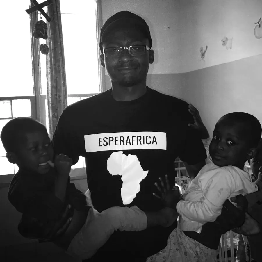 An Esperafrica volunteer holding two young children at a children's home